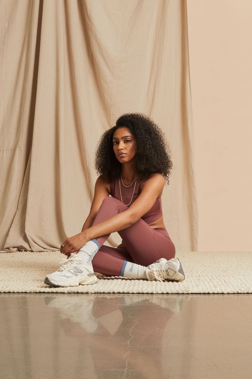 A person standing against a tan studio backdrop.